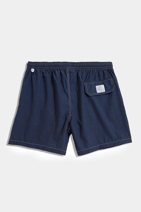 High-end navy blue seersucker swim shorts, Italian navy swimwear, luxury men’s swim shorts, premium seersucker swimming trunks, elegant summer shorts, handcrafted Italian swim shorts, stylish navy trunks, short de bain bleu marine en seersucker fabriqué en Italie, maillot de bain italien haut de gamme, short de bain de luxe pour homme, short de bain élégant en coton gaufré, costume da bagno blu navy in seersucker fatto in Italia, pantaloncini da mare eleganti italiani.